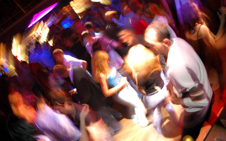 Crowded dance floor with hands in the air
