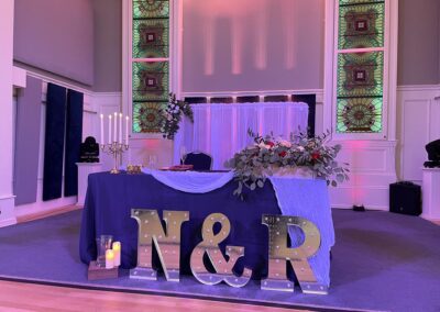Decorated sweetheart table for wedding with large letter's N and R in front of table
