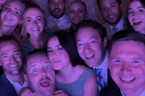 Group shot consisting of 12 people standing in Photo Booth at wedding