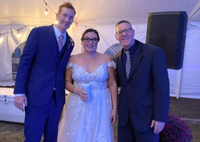 DJ Dave standing with wedding couple inside of wedding tent