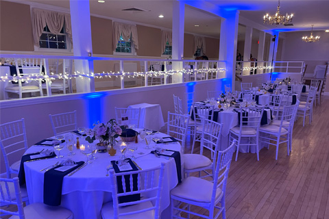 Image of wedding venue with radiating blue lights amongst the tables and chairs